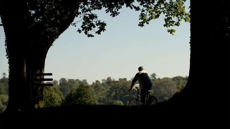 Visitor riding a bicycle in the grounds at Florence Court, Co Fermanagh, Northern Ireland